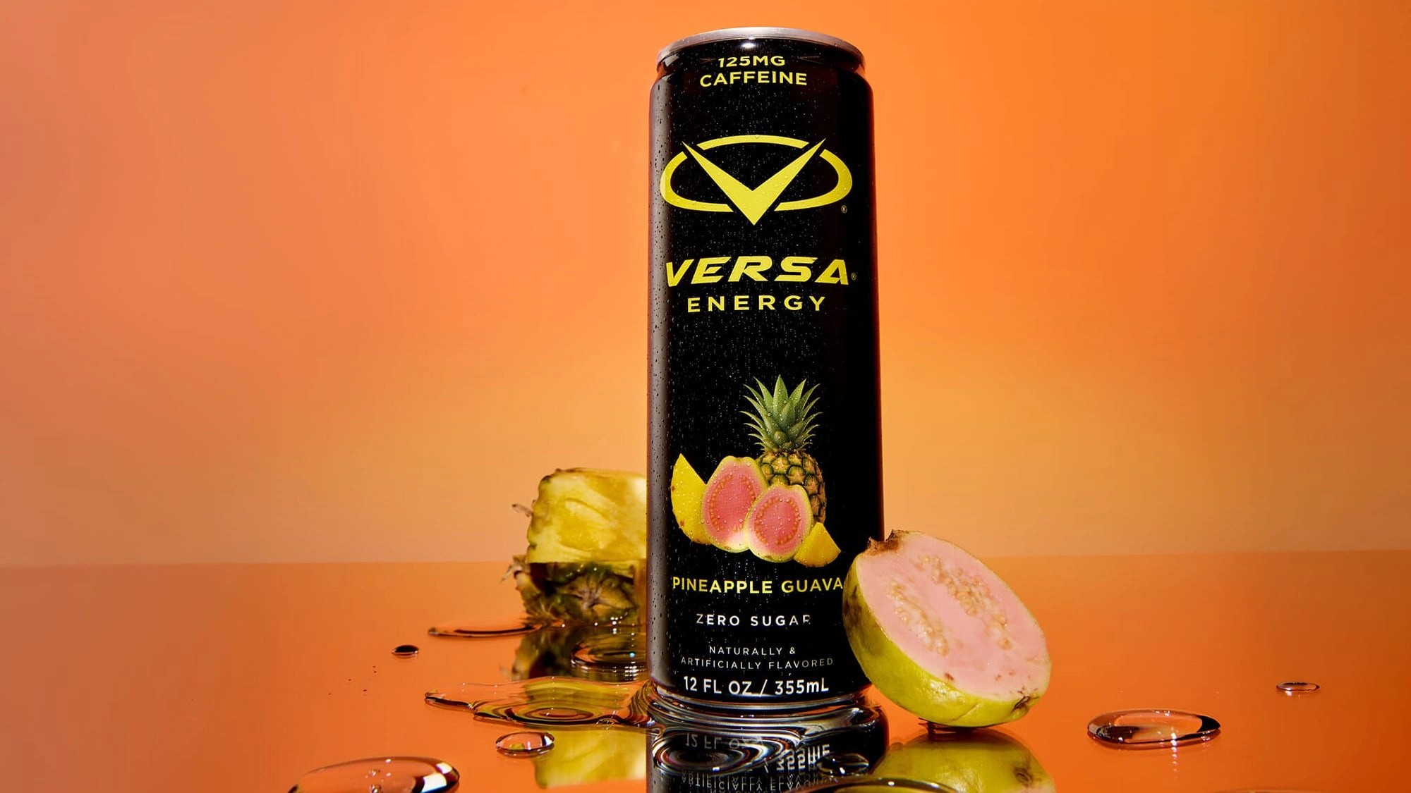 Versa Energy can on an orange background with pineapple and guava