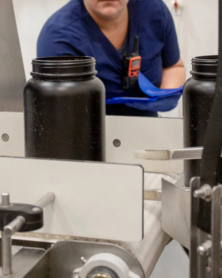 The product on the conveyor belt is checked by a specialist